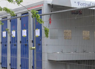 Studenten douchen buiten in festivalcabines