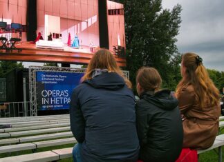 Met paraplu en regenjas naar de opera in het park